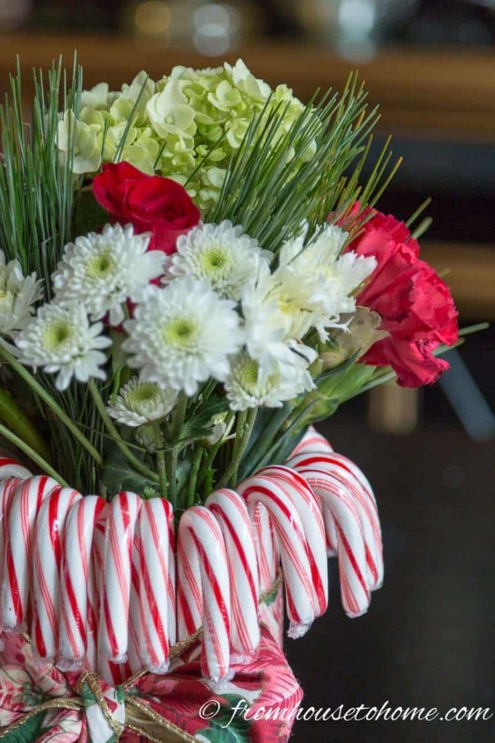 Red and white flowers with pine branches in a DIY candy cane vase