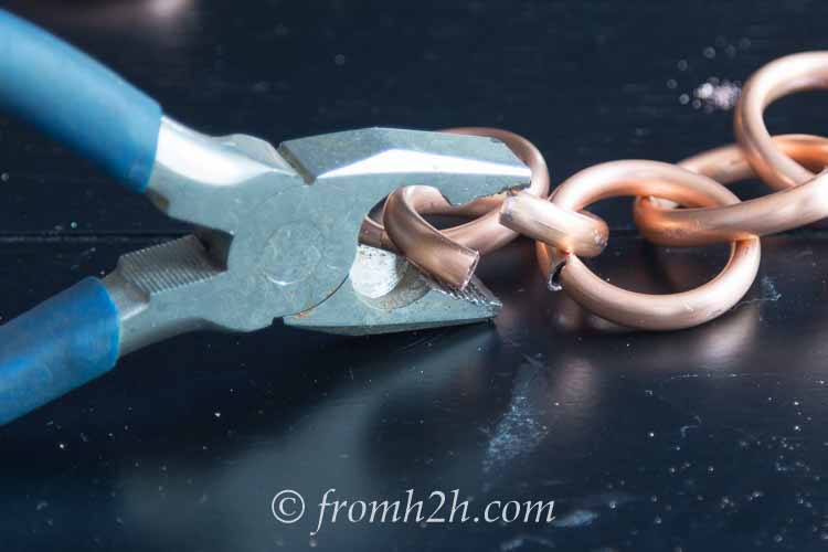Pliers aligning the ends of a chain link