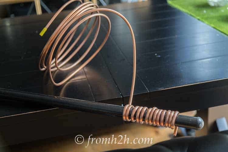Roll of copper tubing with some of it wound around a broomstick