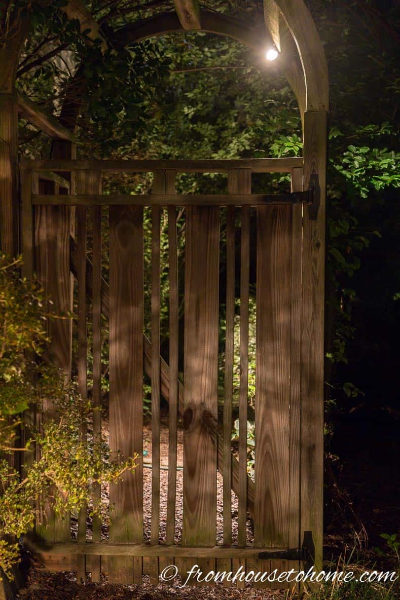Downlighting on an arbor illuminating the pathway under it