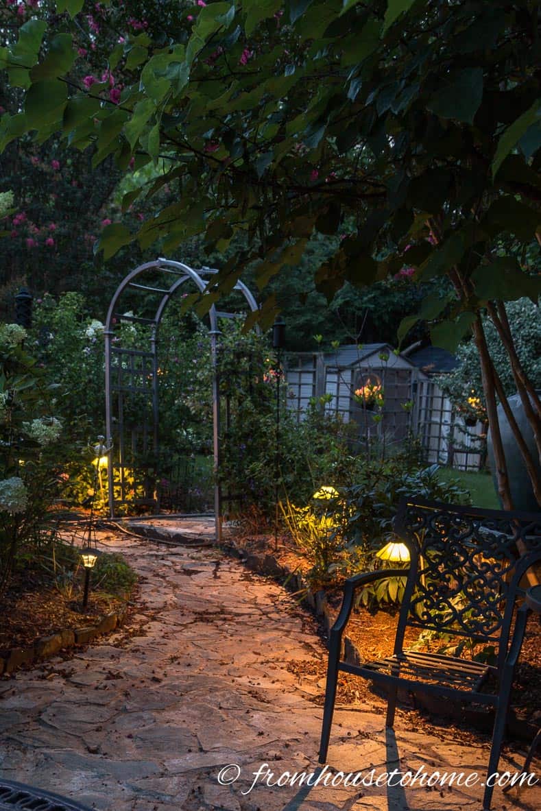 Path lighting along the edges of a backyard walkway and patio