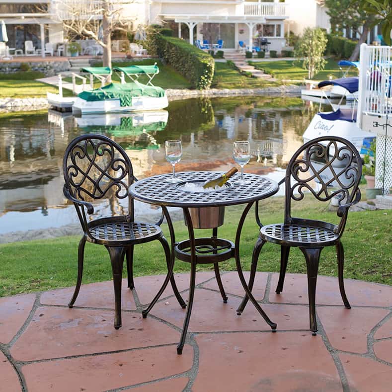 Bistro table with an ice bucket built into the middle of it and two wrought iron chairs