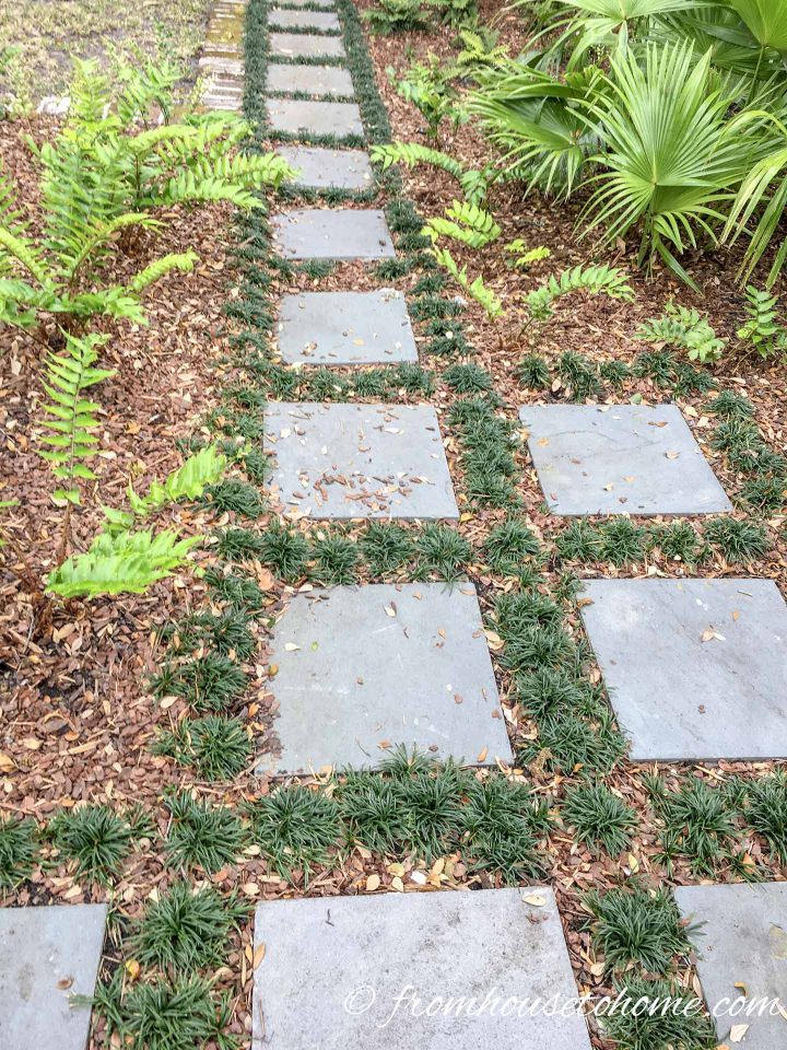 Concrete stepping stones with mulch and grass between them