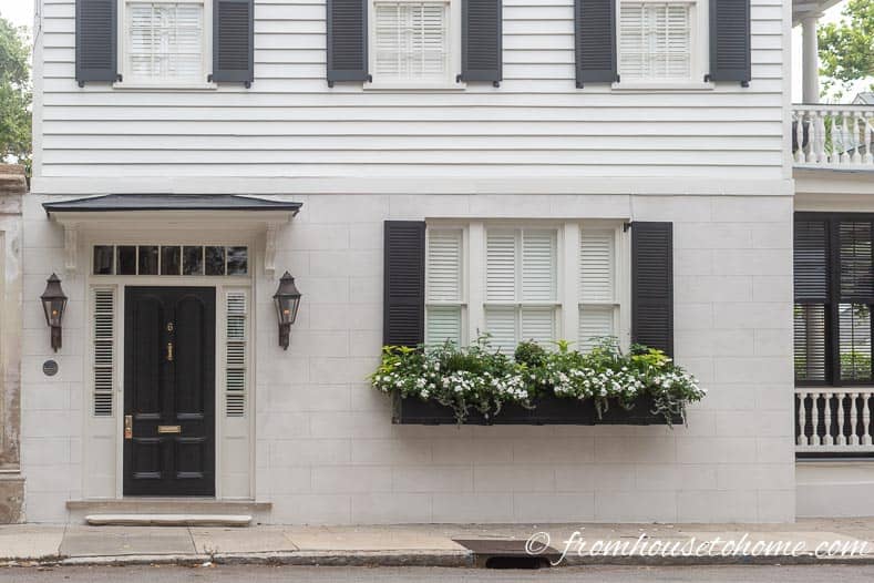 White and black house in Charleston with white flowers in window box