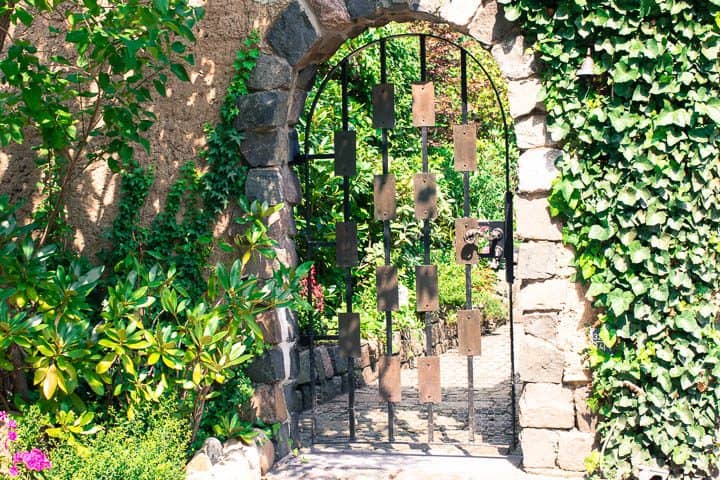 Arched metal door as garden gate