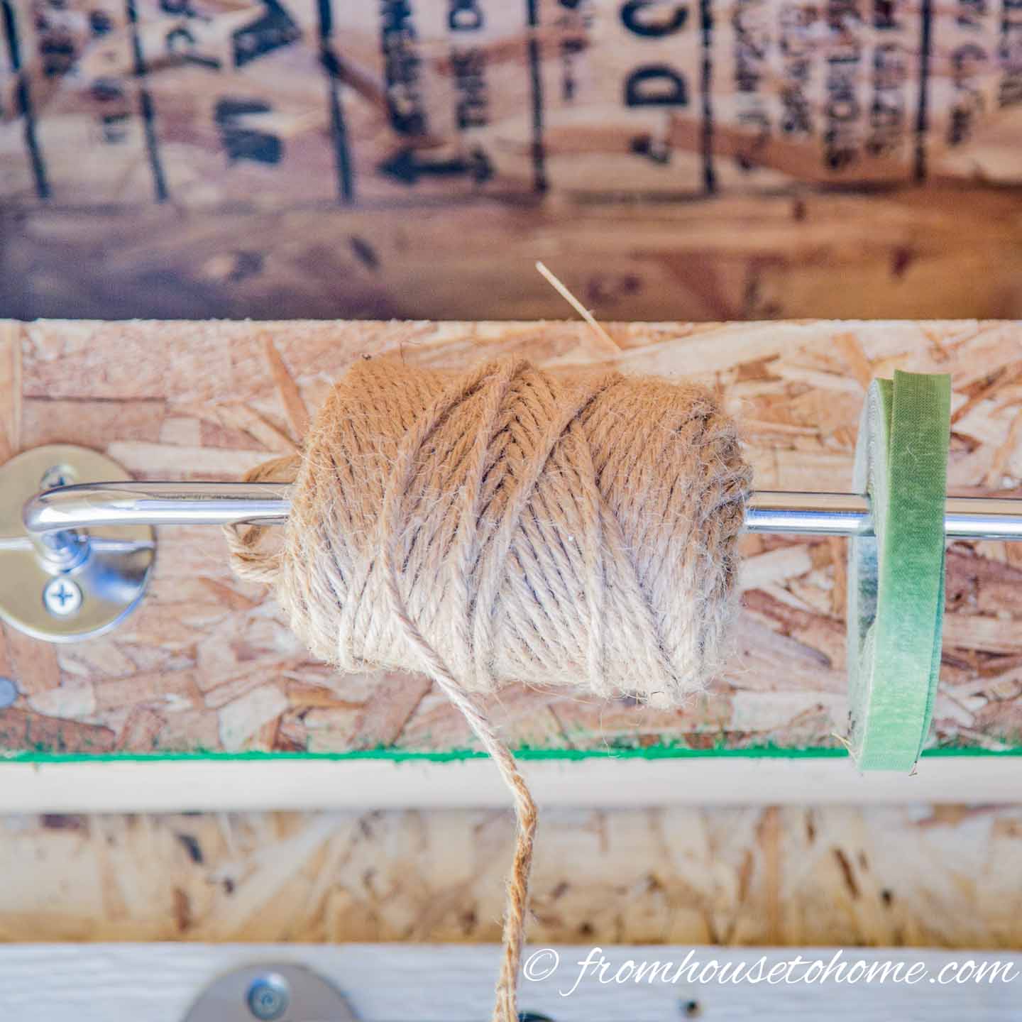 twine and plant ties hanging on a paper towel holder on a shed wall