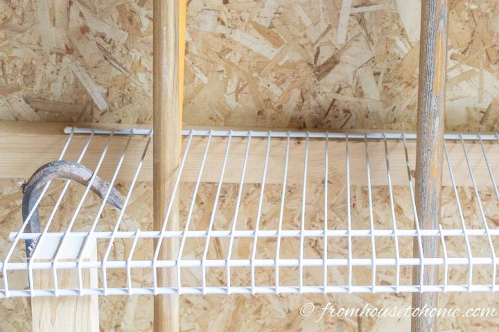 Close up of the wires cut out of the shelves to make holes for storing garden tools like rakes