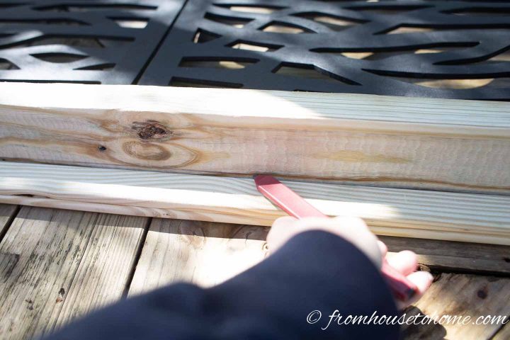 A line being drawn on the outside of the privacy screen frame where the screws should be installed