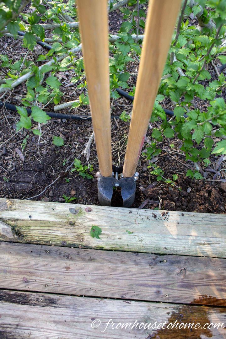 Post hole digger digging a hole for the privacy screen posts