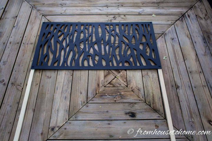 The first decorative panel installed on the wood slats