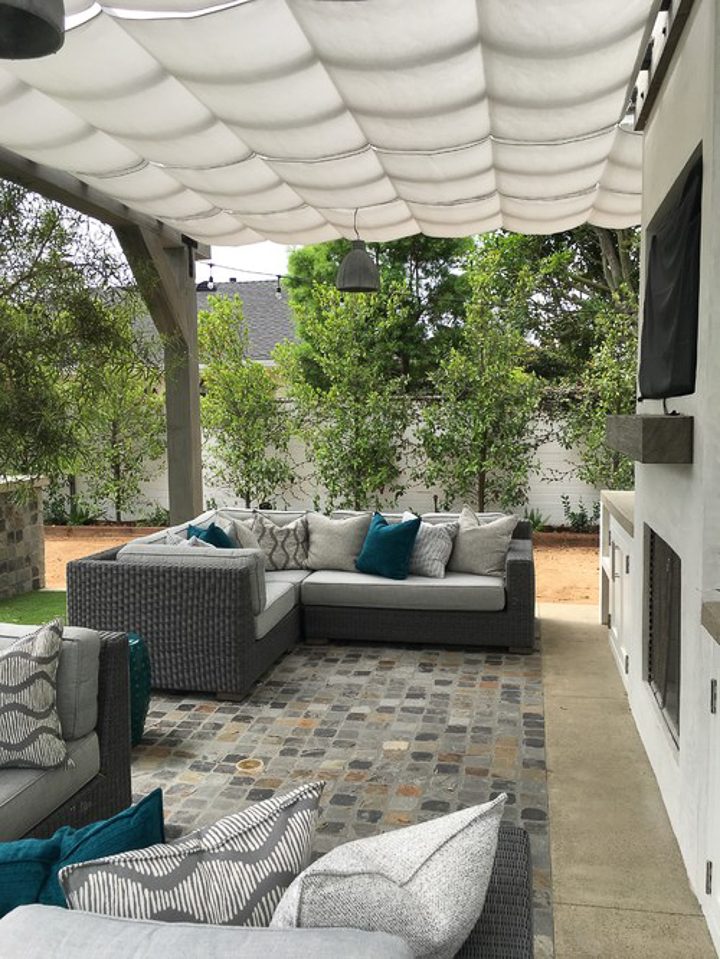 White canvas canopy as a pergola cover over a stone patio