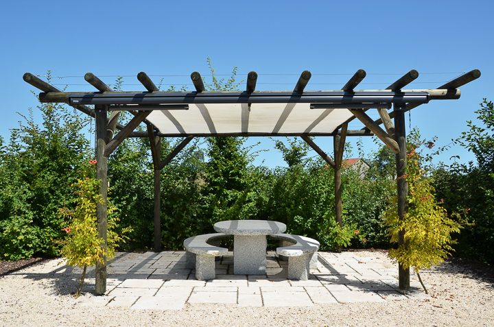 Pergola with a shade sail installed under the beams