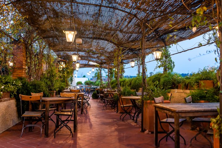 Multiple outdoor pendant lights hanging in a large pergola