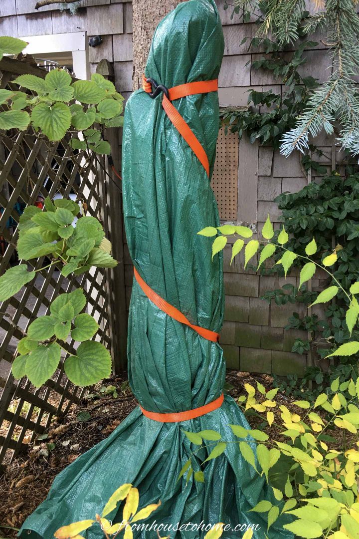 Garden statue wrapped in a tarp to winterize the garden