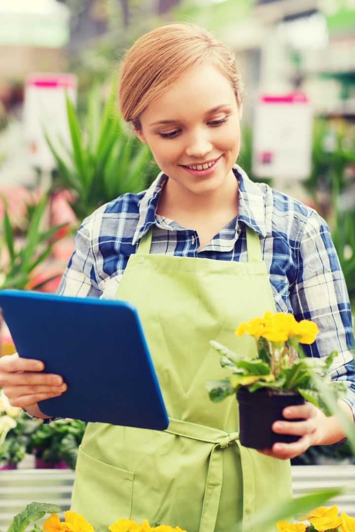 woman using app on a tablet to choose flowers for her garden