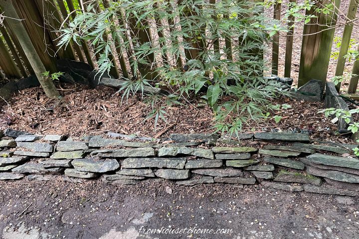 Stacked flagstone edging installed between a pathway and the garden border