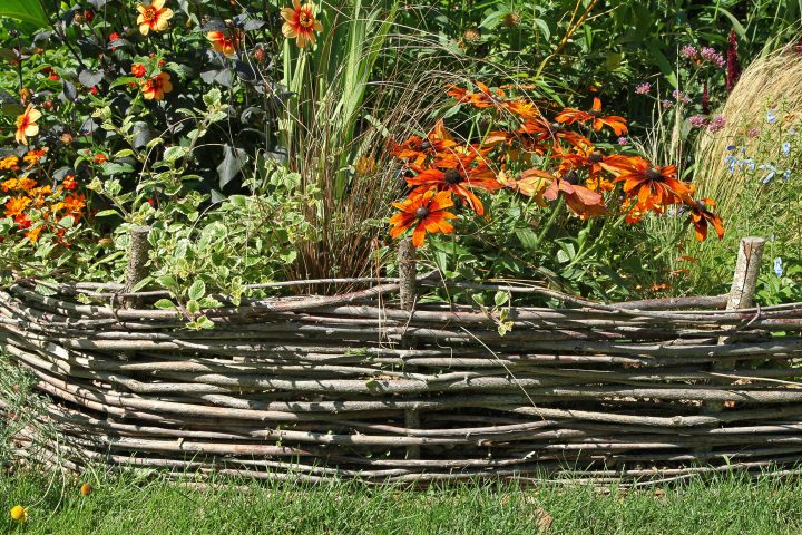 Woven wood mini fence used as garden border edging