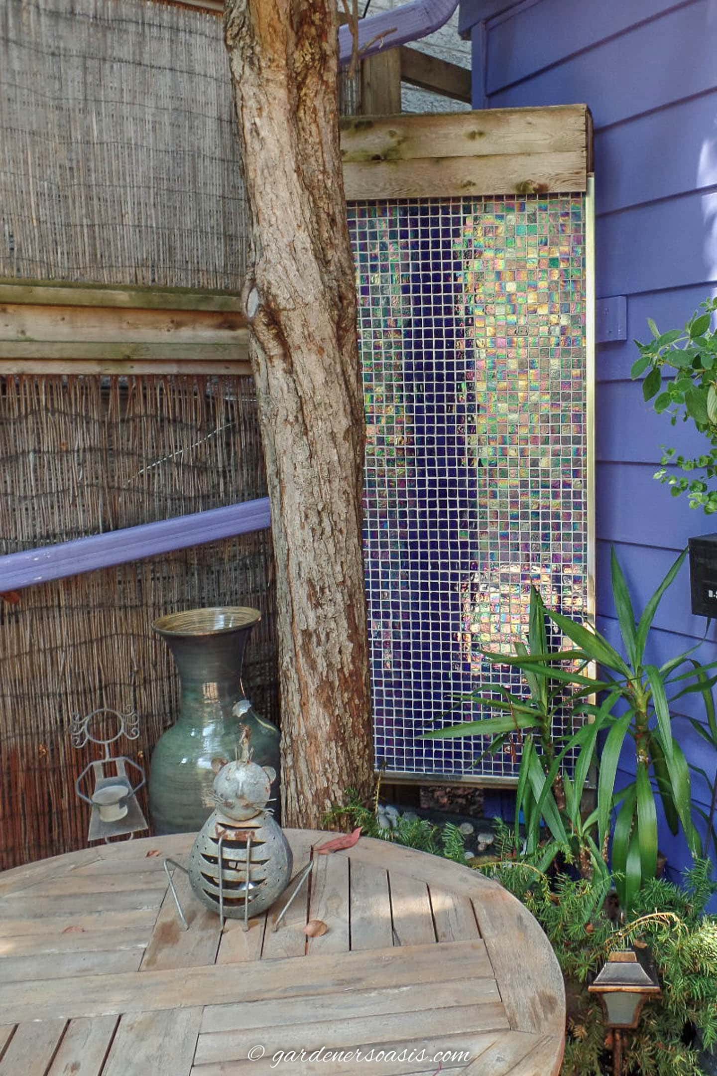 mosaic tile wall water fountain in the corner of a deck