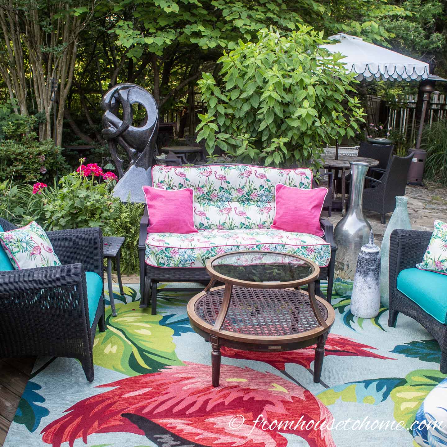 An outdoor sofa, coffee table and two chairs on a small deck