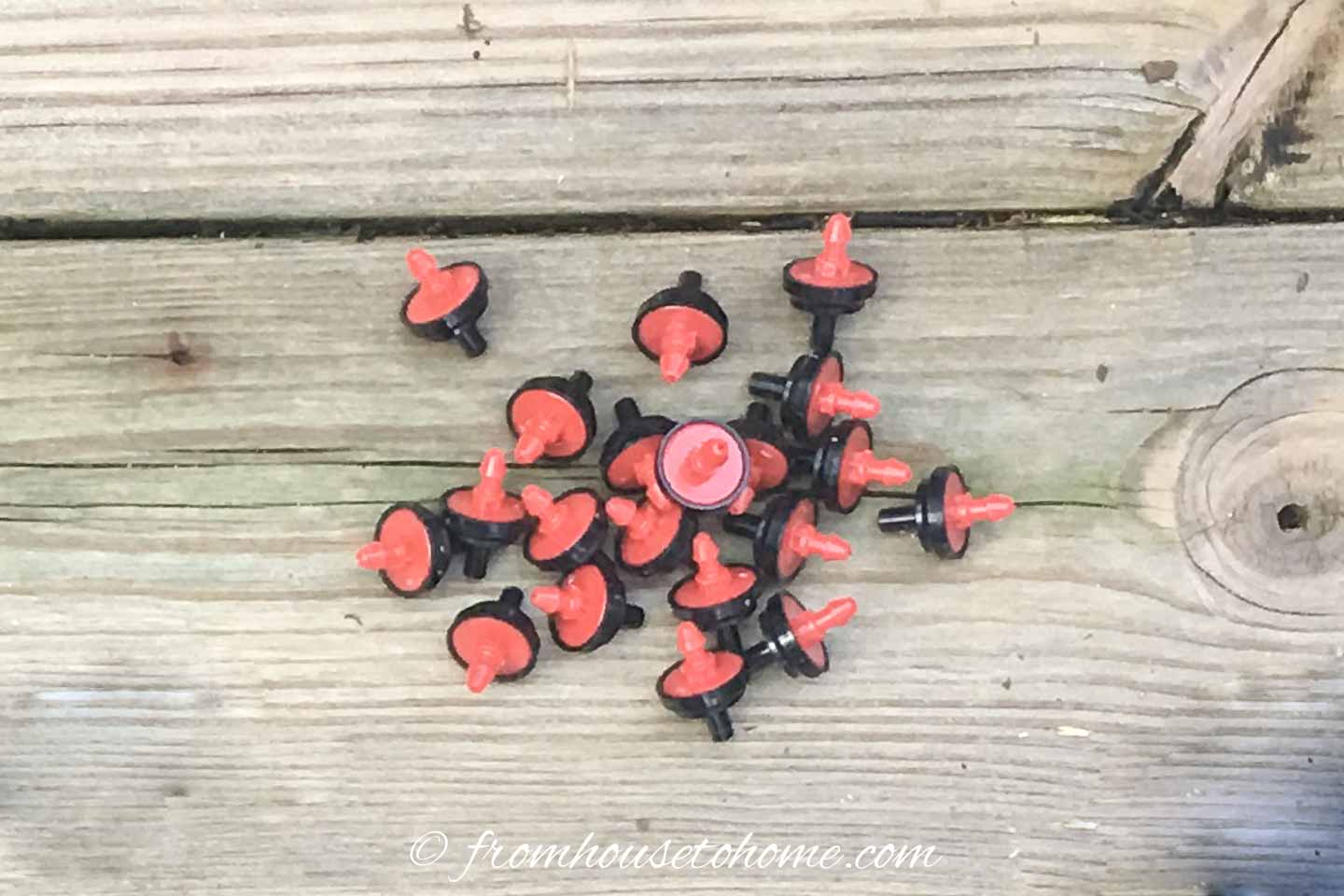 A bunch of planter watering system emitters on a deck