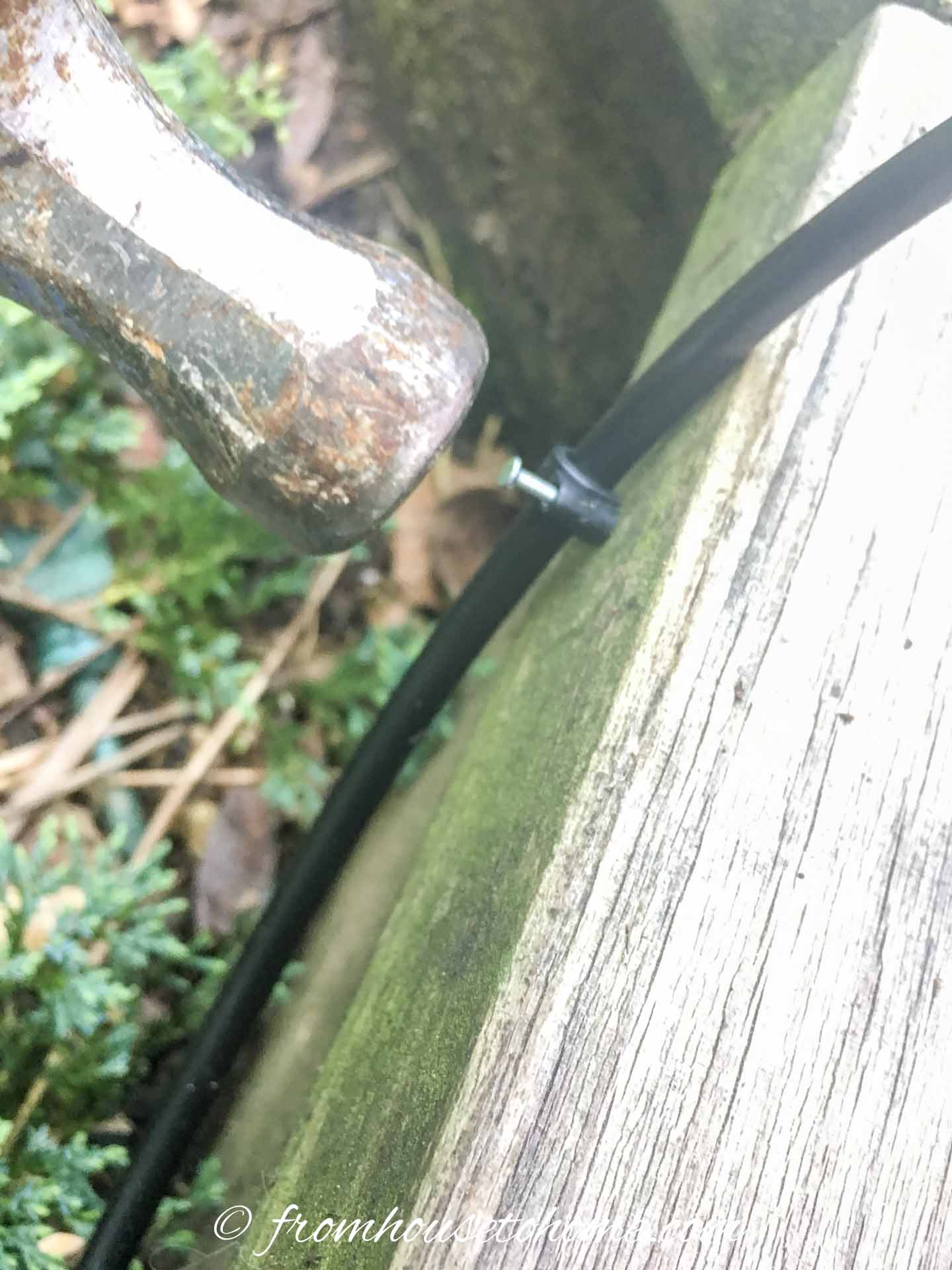 A micro hose being attached to the deck with a cable clamp
