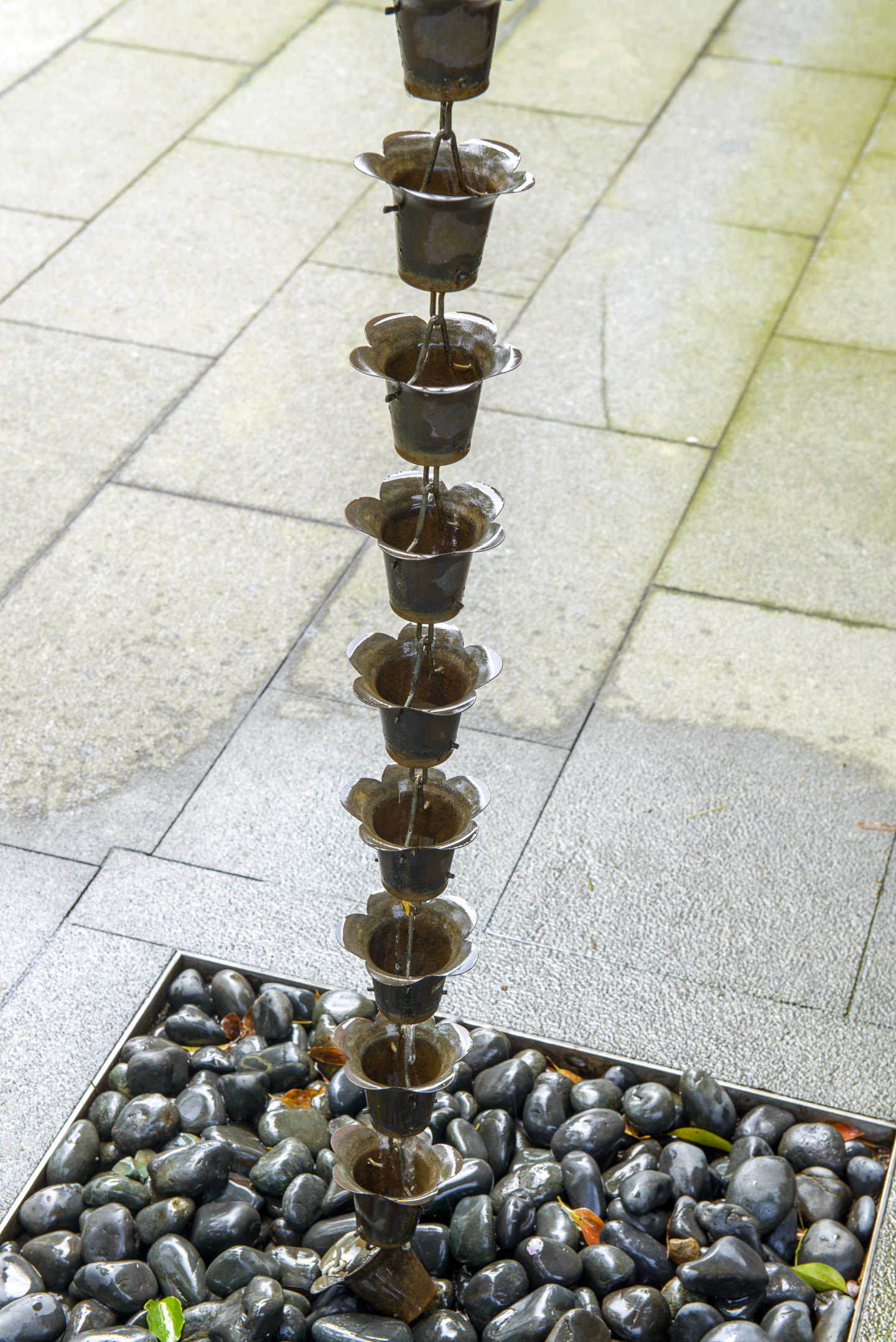 A chain draining into a rock-covered french drain