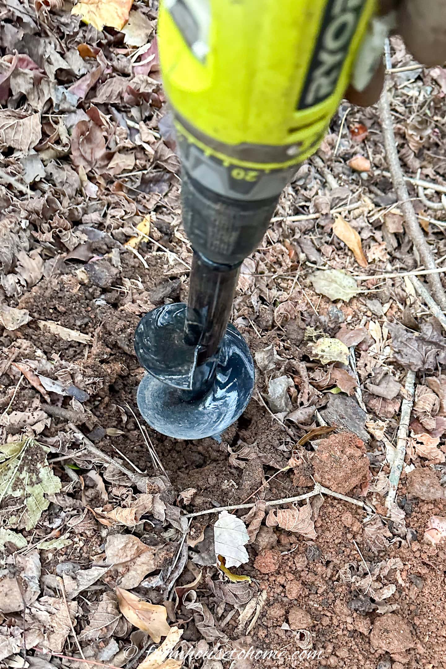 A bulb auger digging a hole in the ground