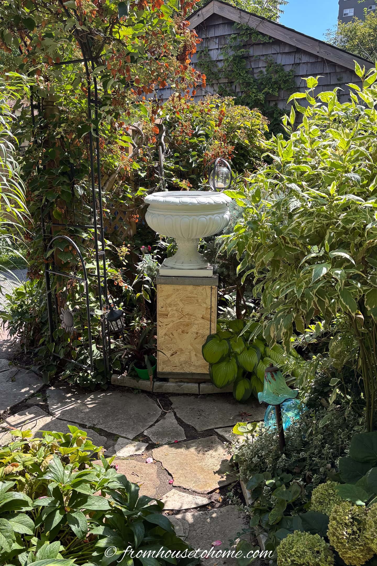 A white planter on top of a DIY garden plinth before the sides have been added