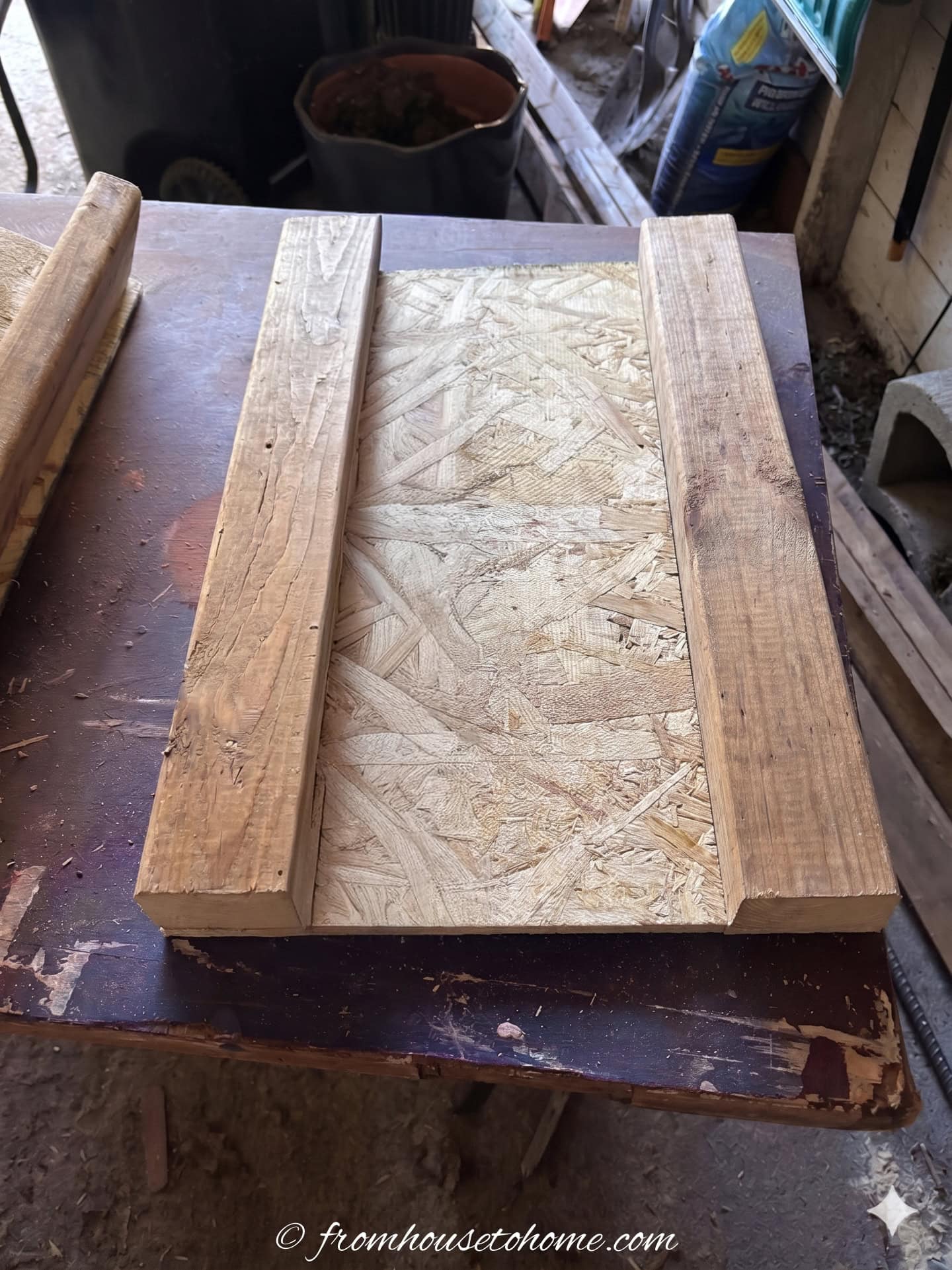 A piece of outdoor plywood with 2 2" x 4" attached to the sides