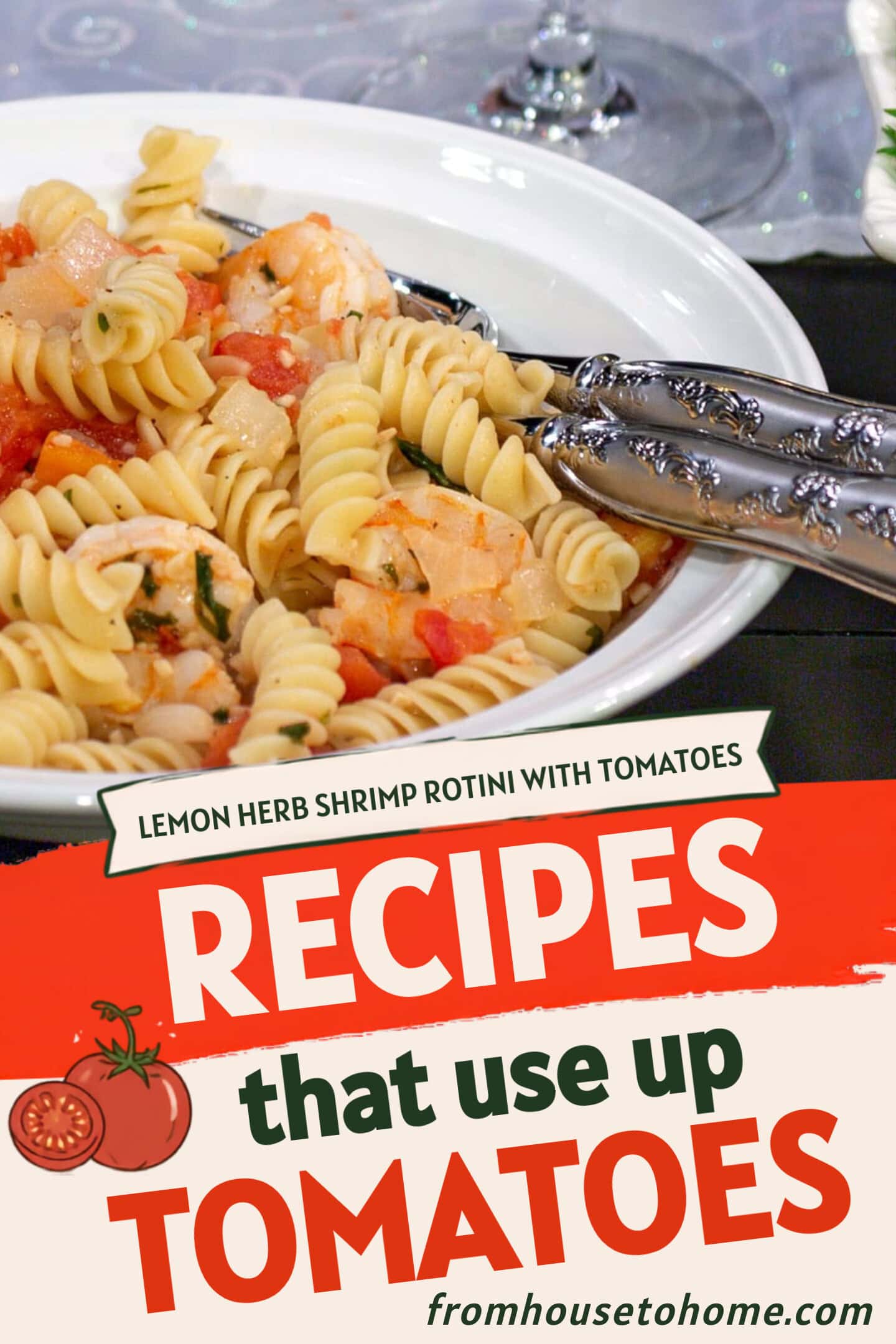 A white bowl of rotini pasta with shrimp, tomatoes, and herbs sits next to a fork and a side salad in a white dish.