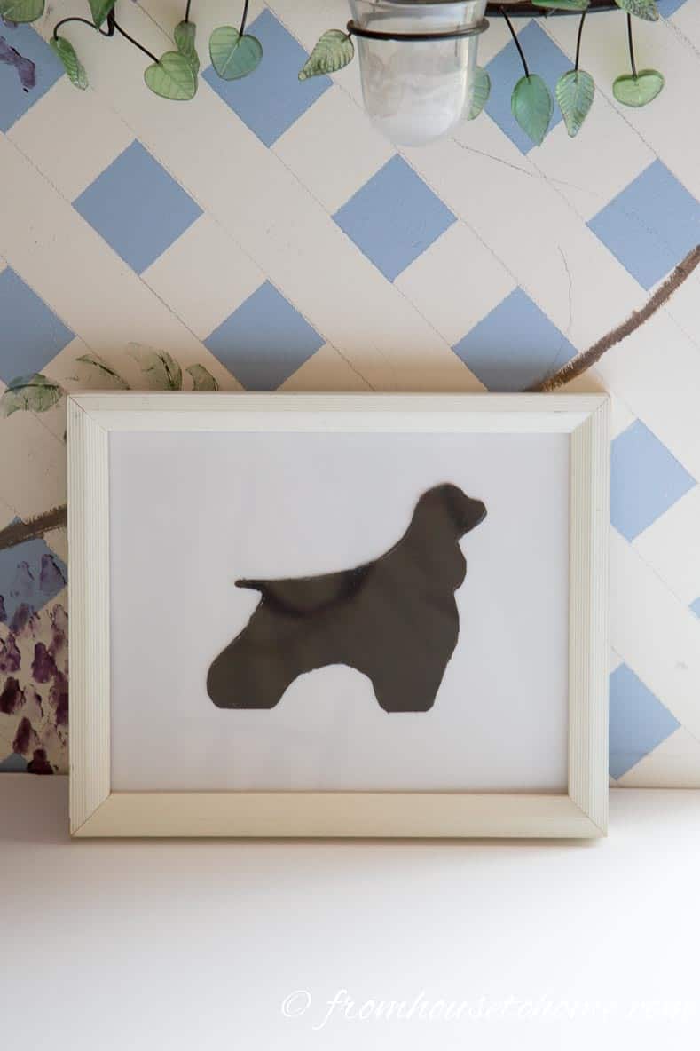 This silhouette dog was cut from paper and glued onto the white mat