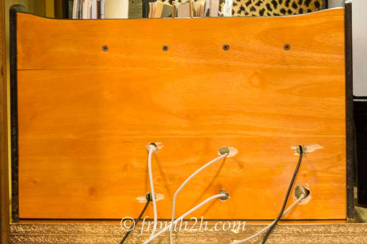 Holes drilled in the back of a small shelf