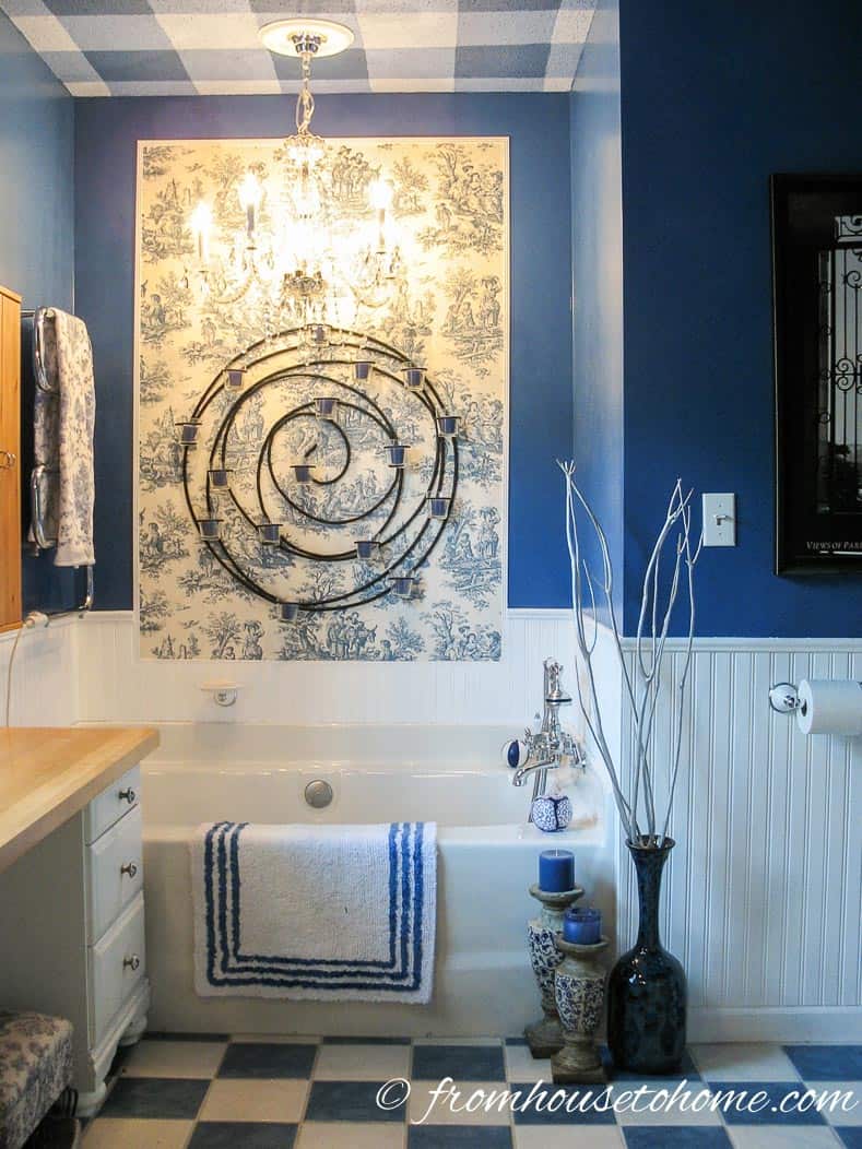 A soaker tub in a blue and white master bathroom with toile accents