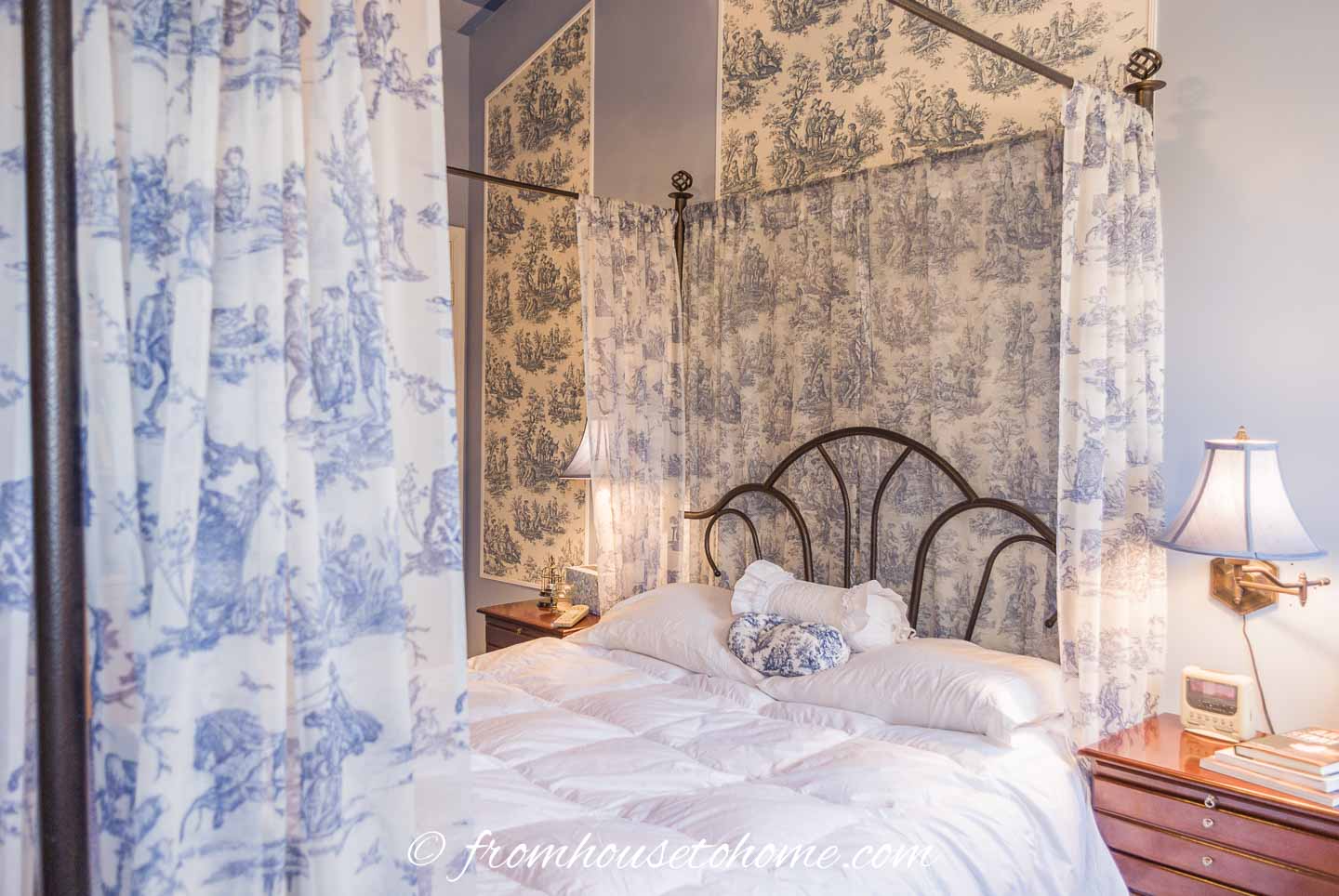 blue and white toile curtains and wallpaper in a master bedroom