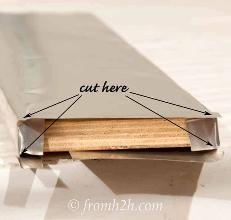 Cut the corners of the aluminum flashing at the ends of the shelf and fold over the side pieces