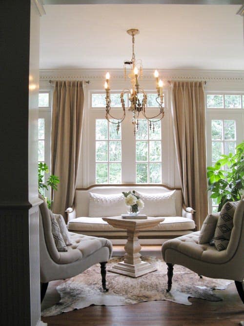 Small living room with large windows and long curtains as the focal point - Photo by Colleen Price