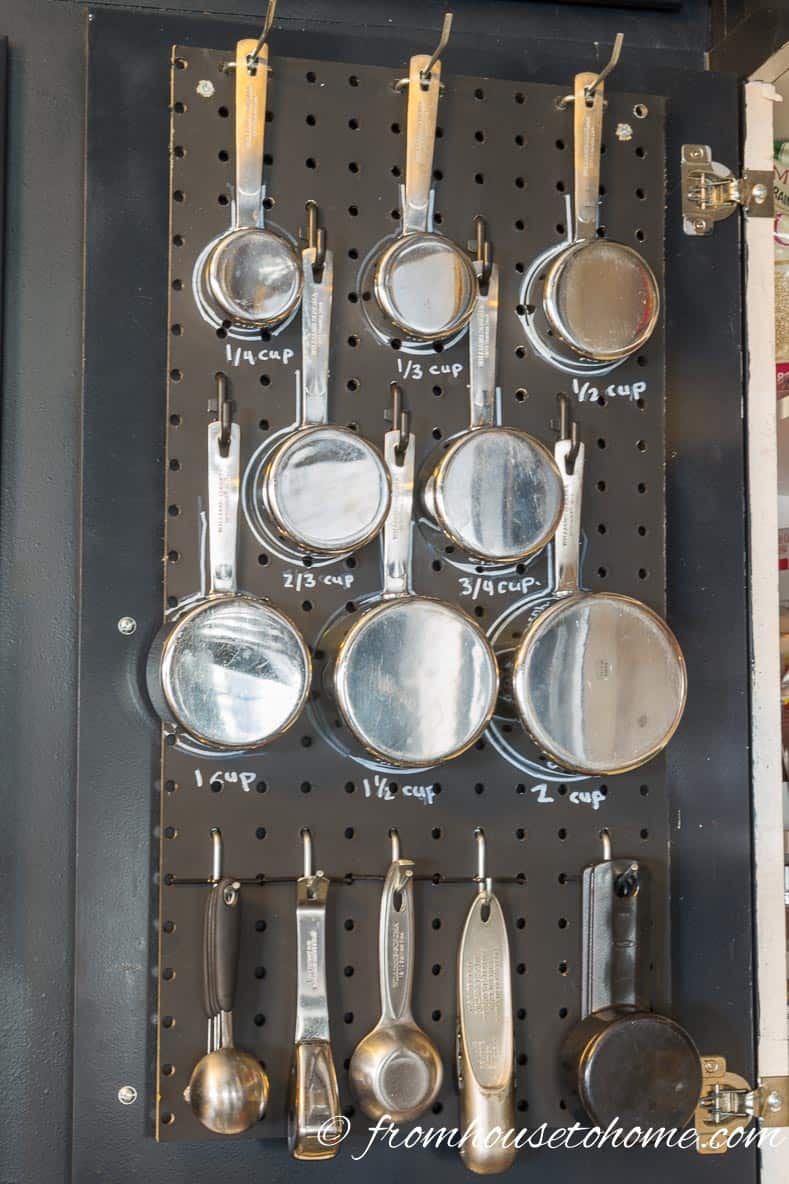 Hanging measuring cups and spoons on the inside of the kitchen cupboard door makes them easy to get to