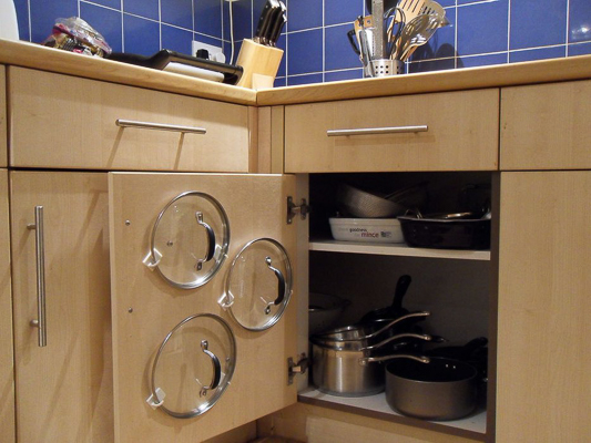 DIY pot lid storage with command hooks on a kitchen cabinet door via instructables.com