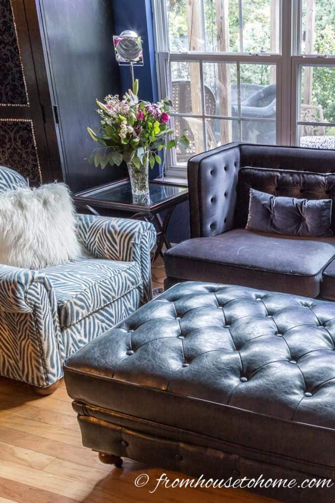 Blue leather ottoman in front of a grey velvet sofa
