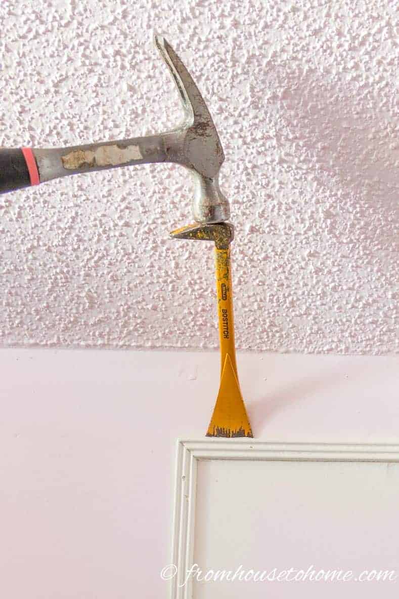 Use a hammer to get in behind the moulding
