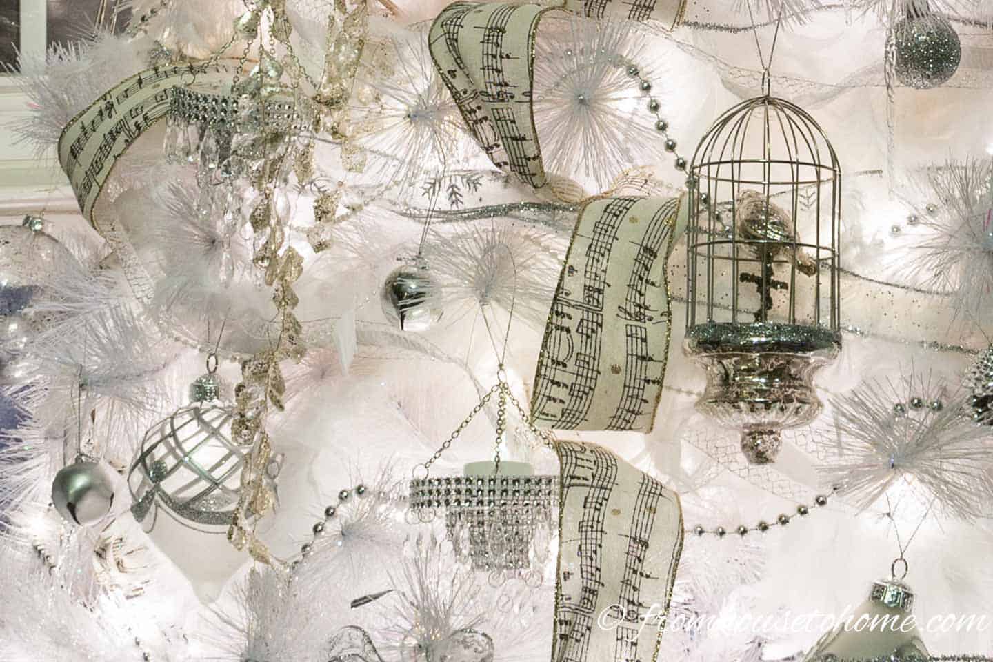 Metal ornaments reflect light to soften an all white Christmas tree