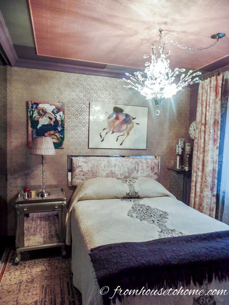 Gray and purple bedroom with wallpapered walls and a painted ceiling