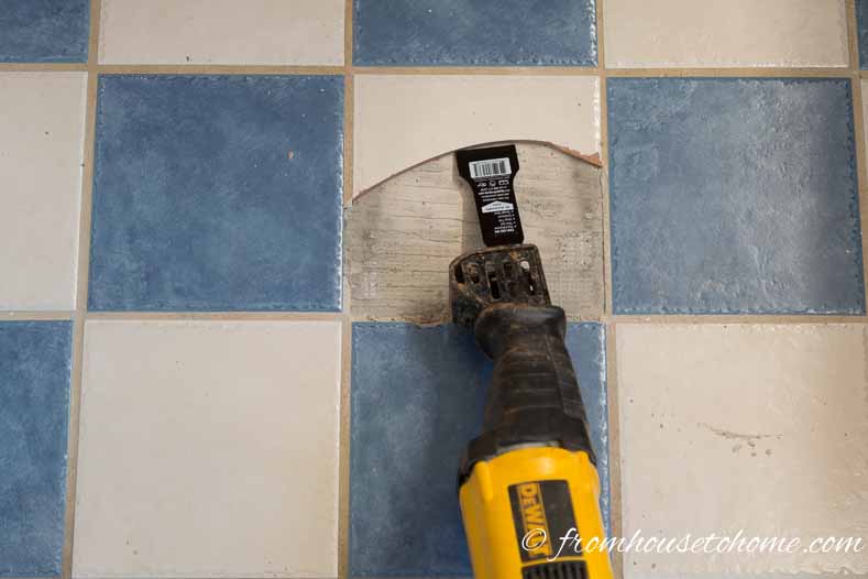 Reciprocating saw / tile scraper blade removing tile from the floor