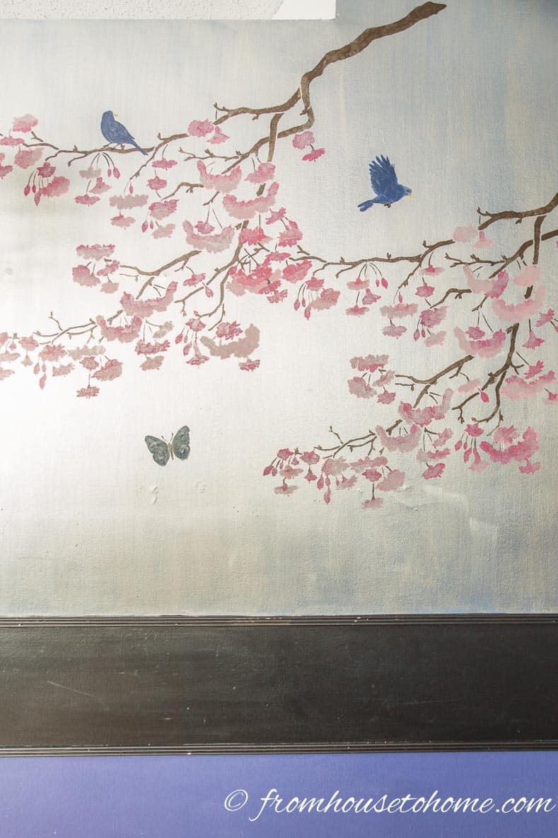 Wall painted silver with cherry trees stenciled on it