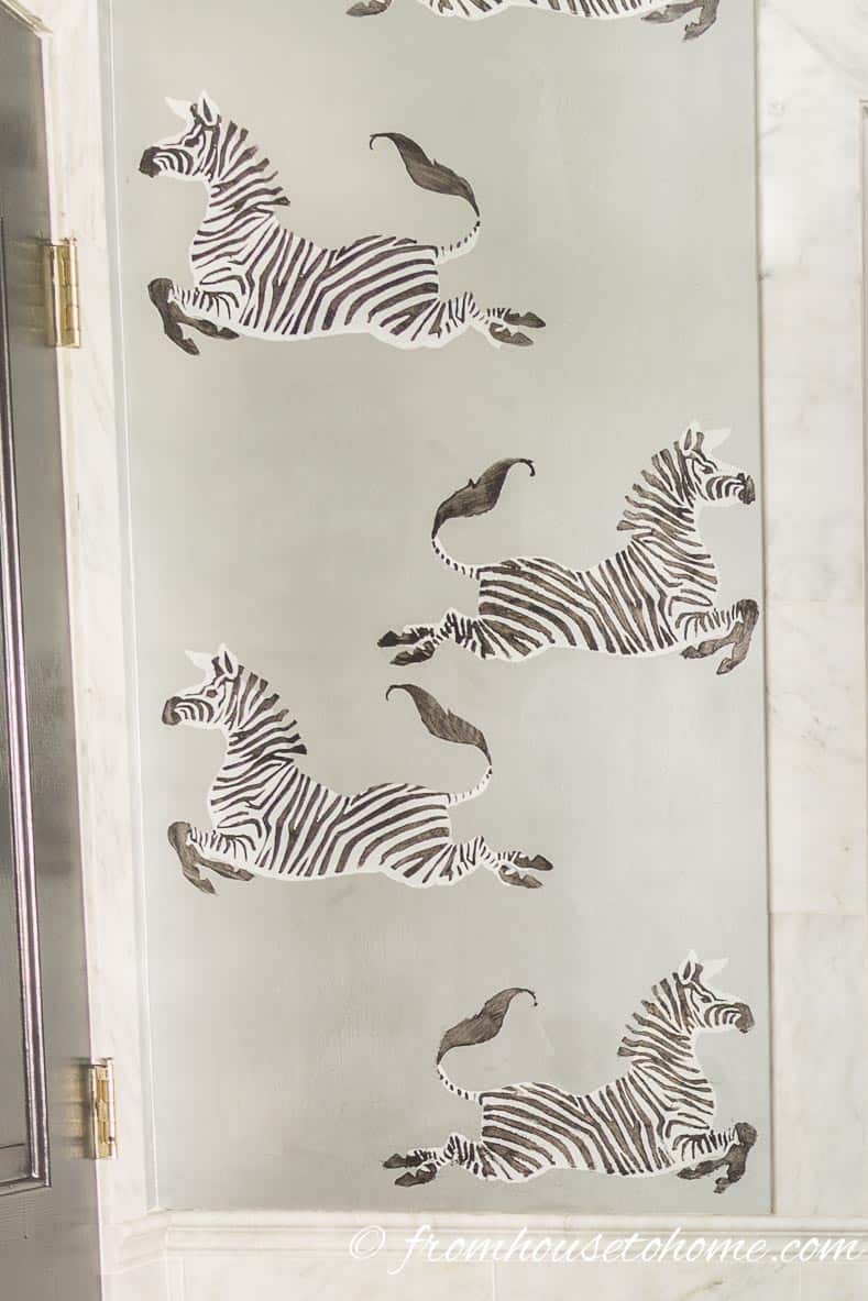 Scalamandre-inspired black and white zebras stenciled on a wall painted silver
