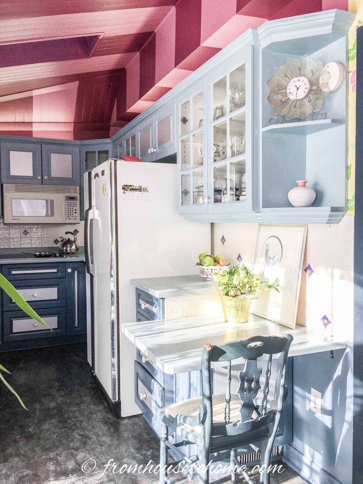 Kitchen with bright pink and burgundy stripes painted on the ceiling