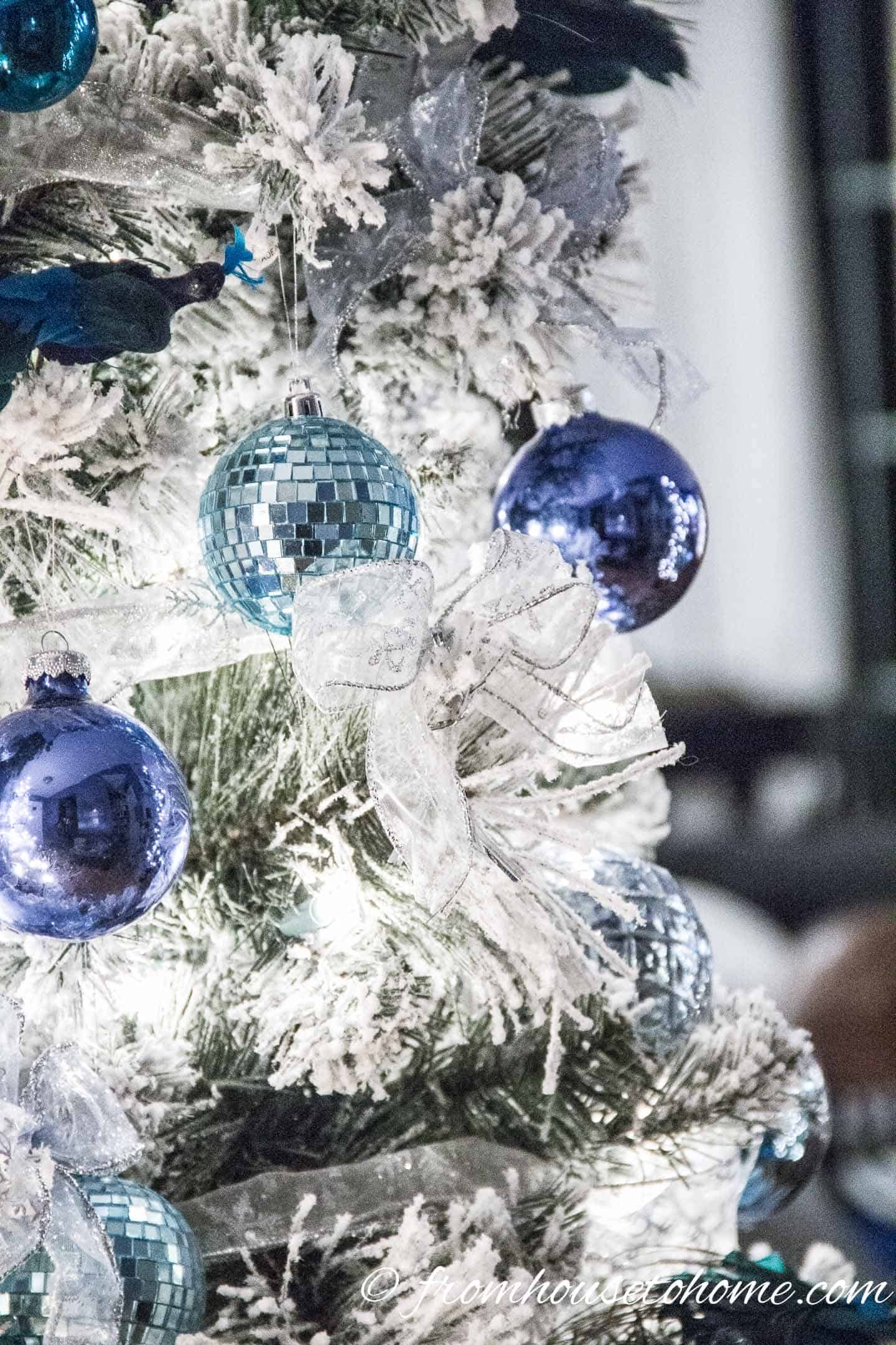 Blue Christmas ornaments on a flocked Christmas tree