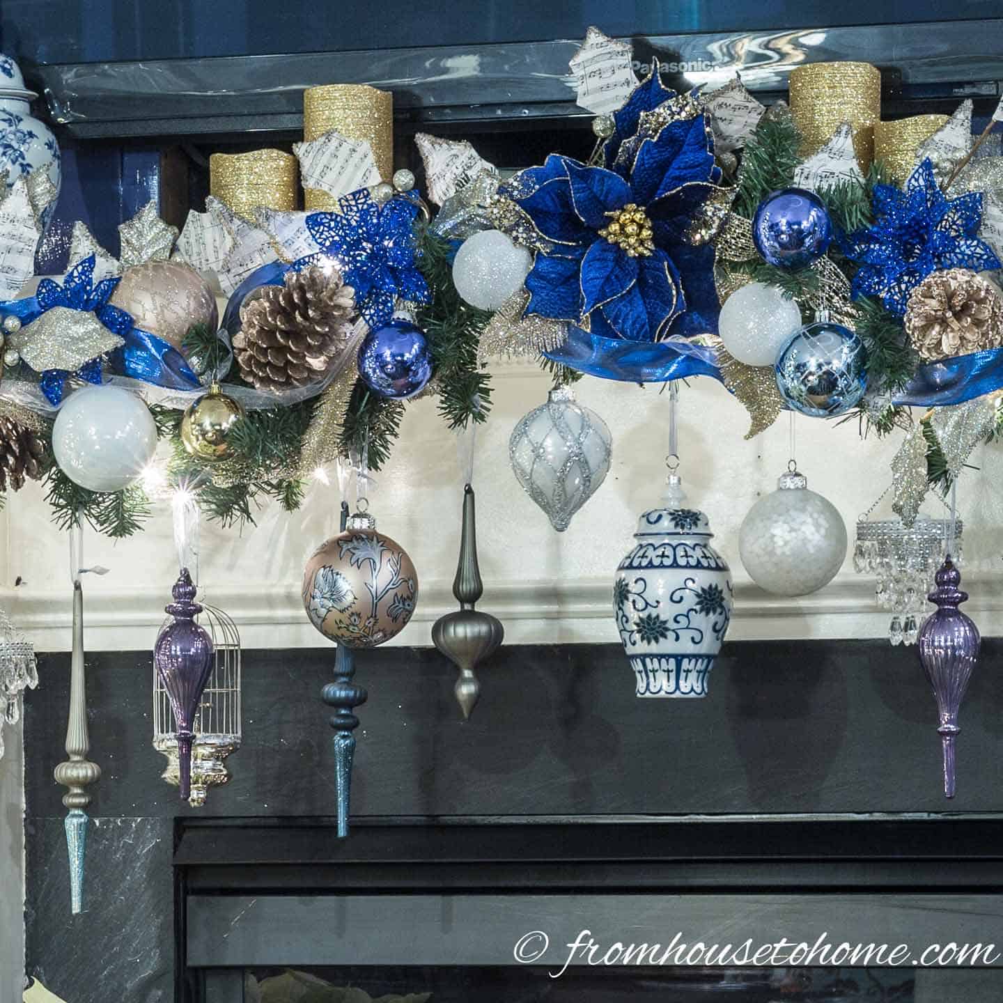 Blue, white and gold Christmas ornaments hung on a fireplace mantel