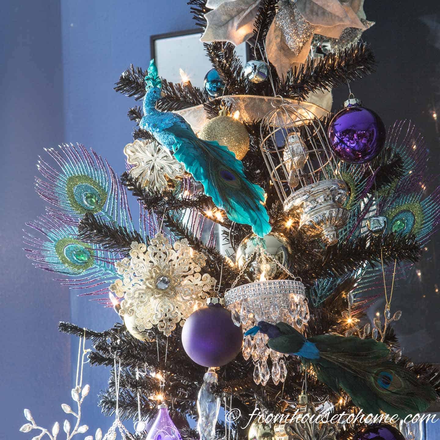 Peacock Christmas ornaments on a black Christmas tree