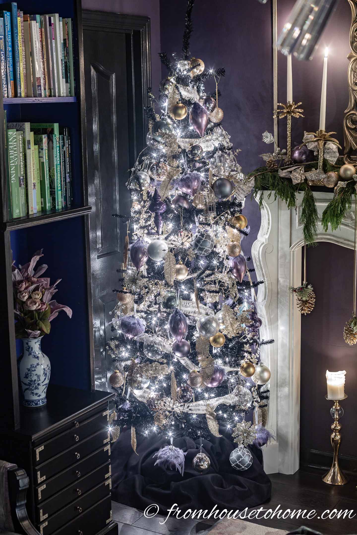 Purple and gold Christmas decorations on a black Christmas tree